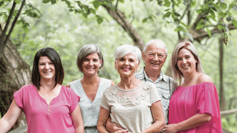 Senior couple with their three daughters on a bridge.  Couple de seniors avec leurs trois filles sur un pont