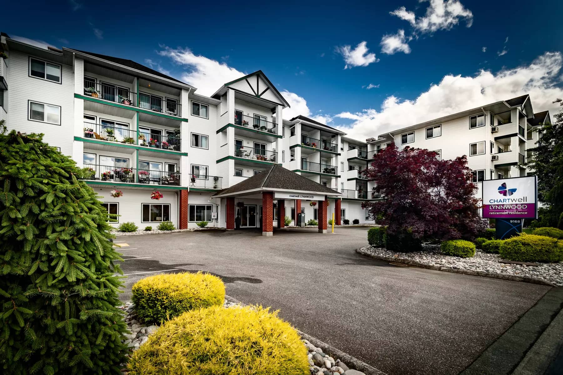 wide angle exterior picture of the front of the building and entrance at chartwell lynnwood house retirement residence