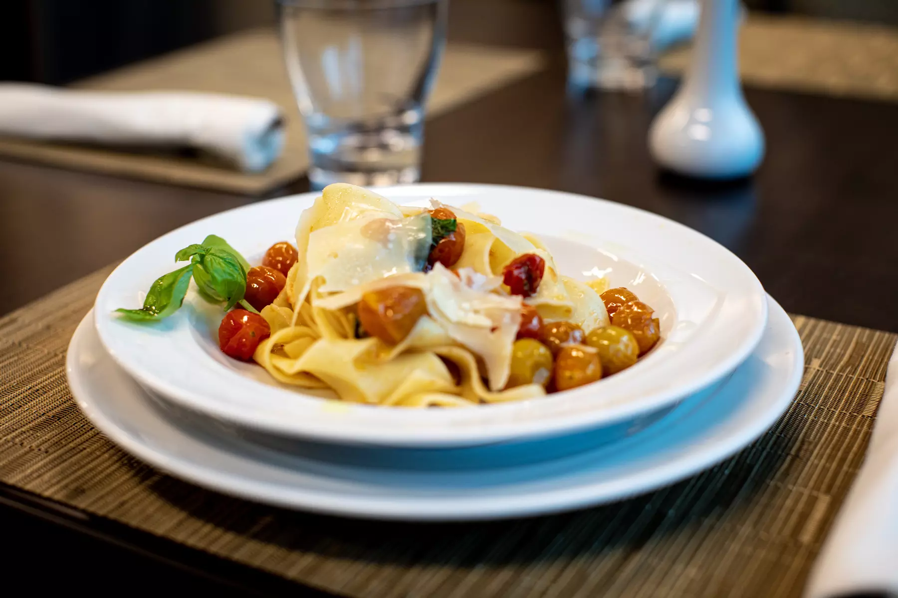 Pasta cooked in olive oil with grape tomatoes and basil