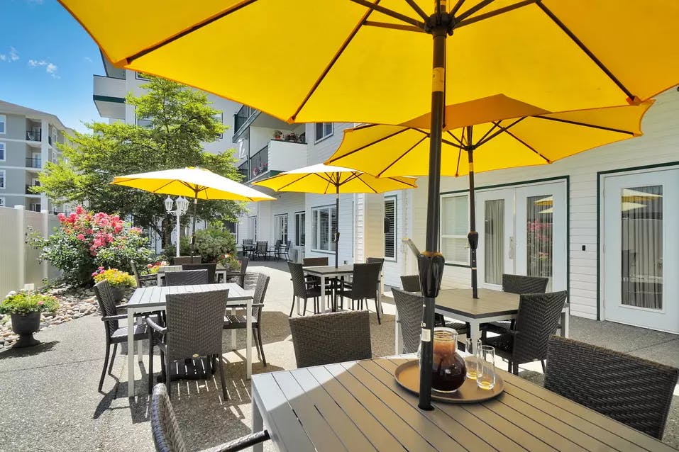 Chartwell Lynnwood's exterior with tables and umbrellas