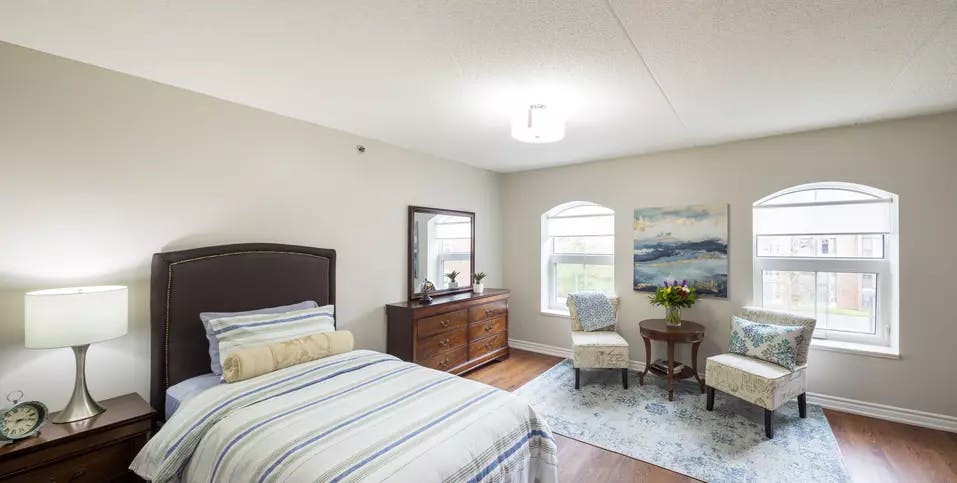 Chartwell Martha's Landing Retirement Residence bedroom with seating and lovely natural light