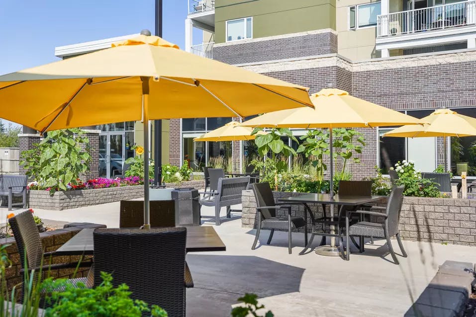 patio furniture with umbrellas at chartwell heritage valley retirement residence