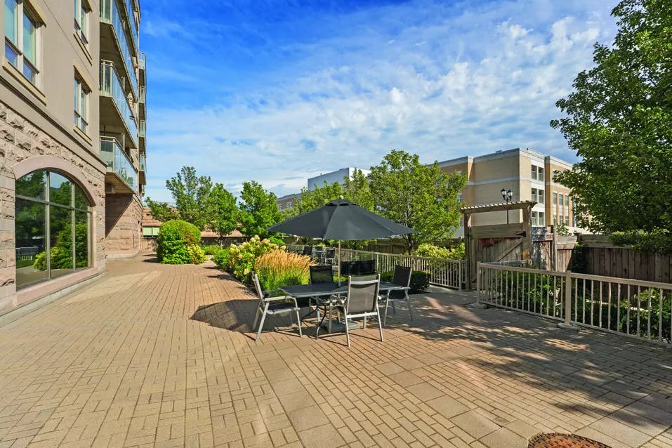 Chartwell Oakville Retirement Residence outdoor patio with umbrella and walking space. 