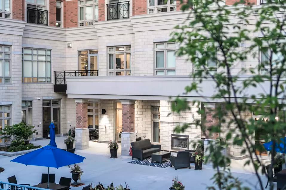 Outdoor fireplace with patio furniture at Chartwell Waterford Retirement Residence