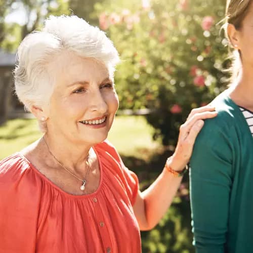 Senior woman with her hand on her daughter's shoulder.  Femme âgée posant la main sur l'épaule de sa fille