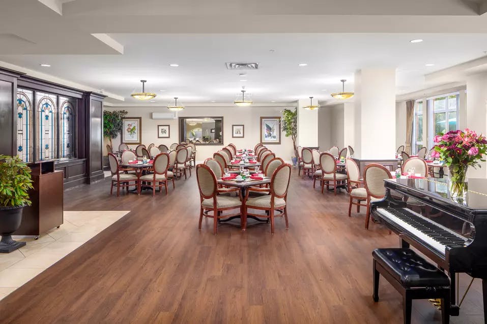 Gorgeous open concept dining room with piano at Chartwell Churchill House Retirement Residence