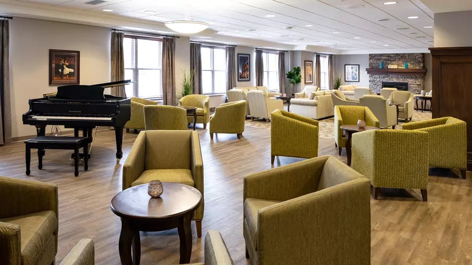 Lounge with piano and entertainment space at Chartwell Balmoral Retirement Community.