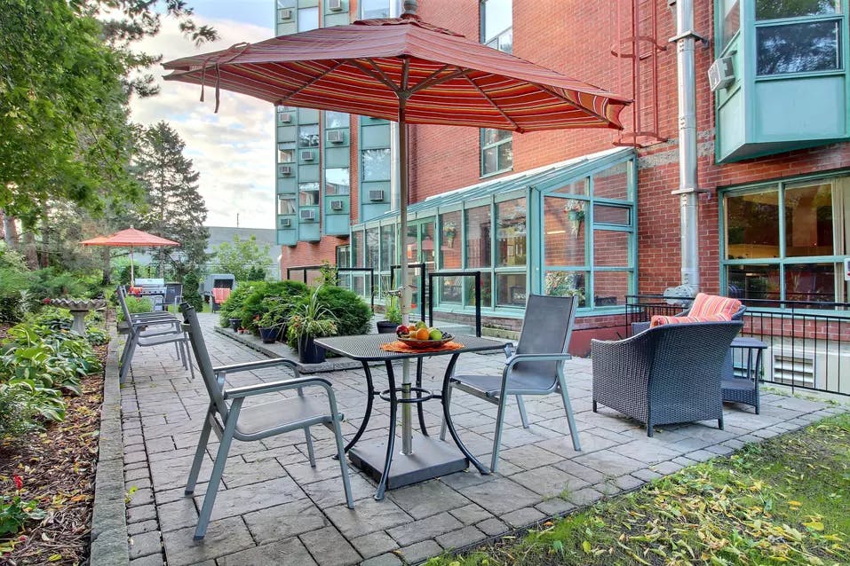outdoor patio at chartwell chateau cornwall retirement residence terrasse extérieure avec table et parasols