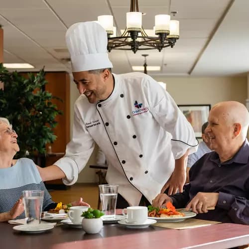 Chartwell Cheff having a pleasant conversation with the Senior couple at the dinning table / Le Cheff de Chartwell a une conversation agréable avec le couple senior à la table à manger