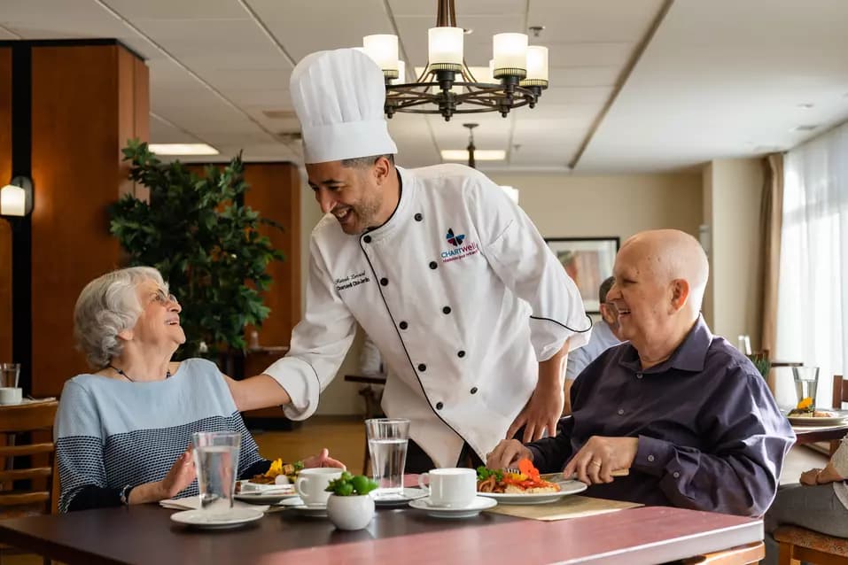 Chartwell Cheff having a pleasant conversation with the Senior couple at the dinning table / Le Cheff de Chartwell a une conversation agréable avec le couple senior à la table à manger