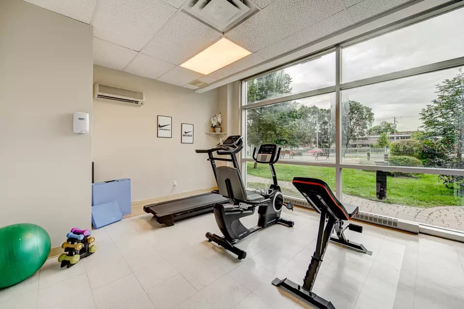 Salle de conditionnement physique avec équipement d'exercice chez Chartwell Belvédères de Lachine / Fitness room with exercising equipment at Chartwell Belvédères de Lachine