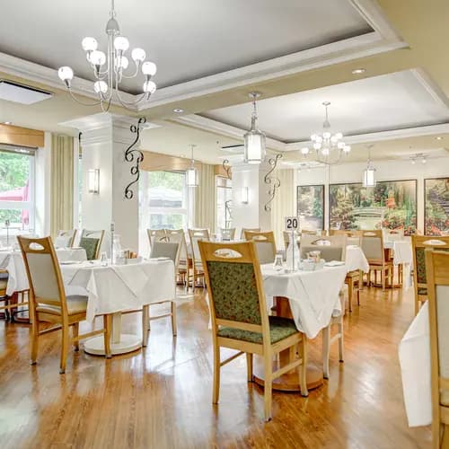 Salle à manger avec tables et chaises fenêtres et magnifique murale Chartwell Appartements de Bordeaux résidence pour retraités