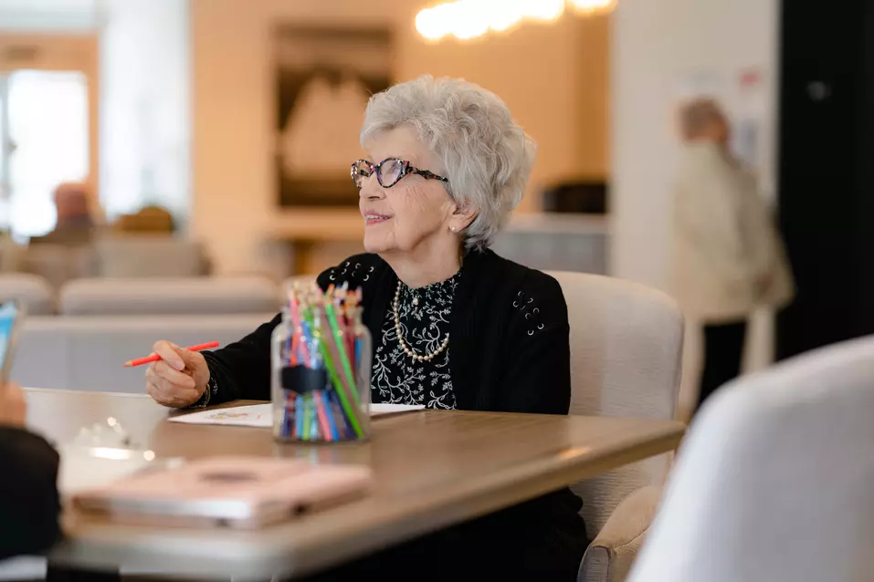Chartwell Senior resident  enjoying art session by colouring a picture