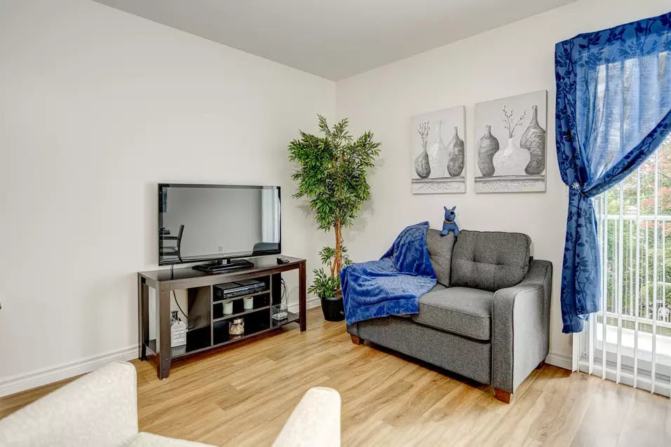 Salon appartement modèle avec télévision et divan Chartwell Notre-Dame de Victoriaville résidence pour retraités