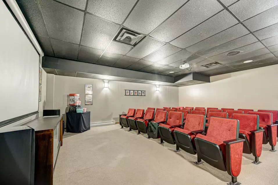 Salle de cinéma avec grand écran de projection chez Chartwell Belvédères de Lachine / Theater room with large projector screen at Chartwell Belvédères de Lachine