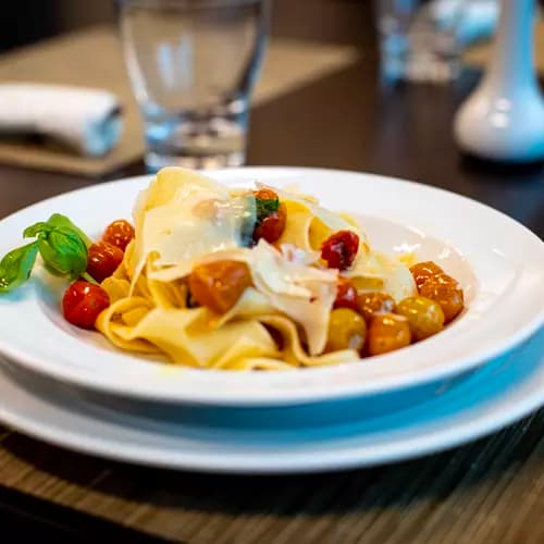 Pasta cooked in olive oil with grape tomatoes and basil