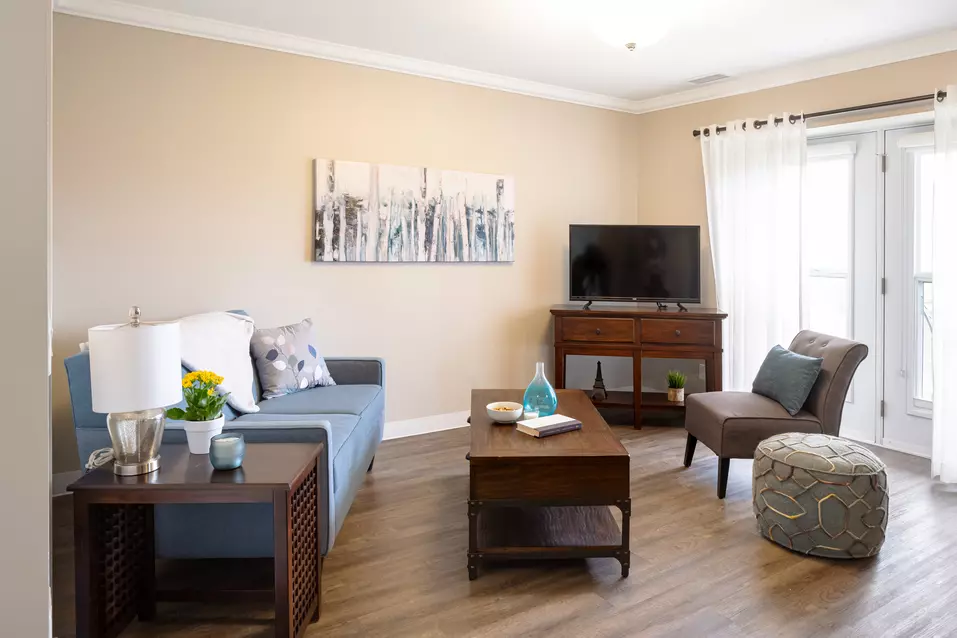 Suite living room with floor to ceiling windows at Chartwell Balmoral Retirement Community.
