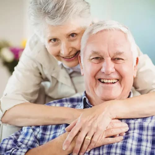 Senior couple embracing, man sitting, woman  embraces man / Couple de seniors s'embrassant, homme assis, femme embrassant l'homme