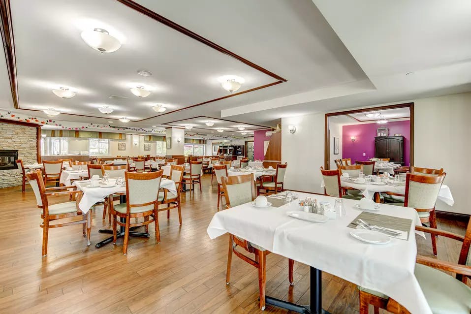 Salle à manger avec tables et chaises Chartwell Manoir Archer résidence pour retraités