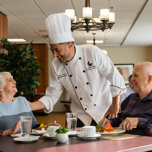 Chartwell Cheff having a pleasant conversation with the Senior couple at the dinning table / Le Cheff de Chartwell a une conversation agréable avec le couple senior à la table à manger