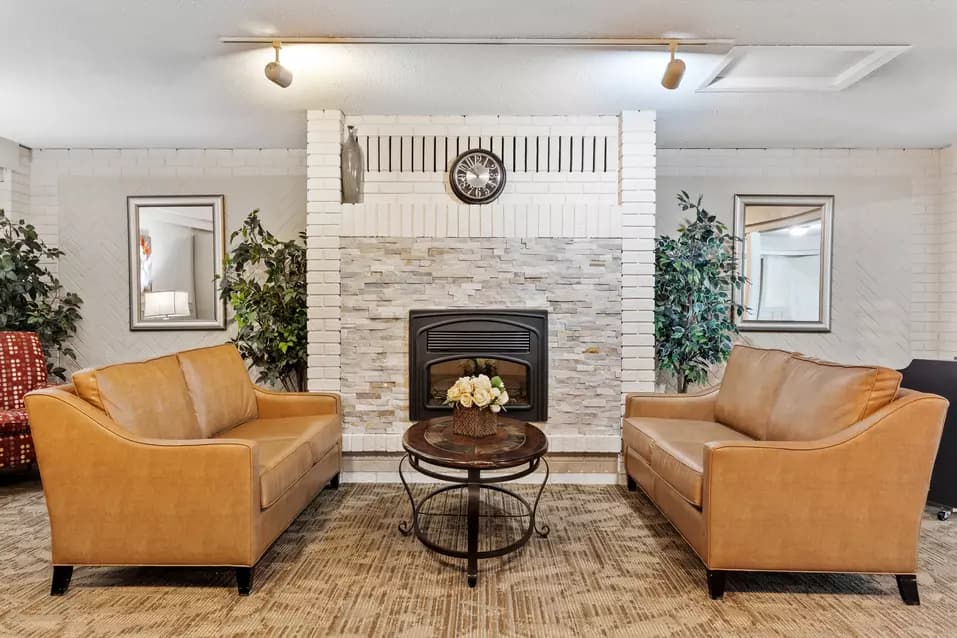 Sitting area in front of a fireplace at Chartwell Pinewood / Coin salon devant une cheminée à Chartwell Pinewood