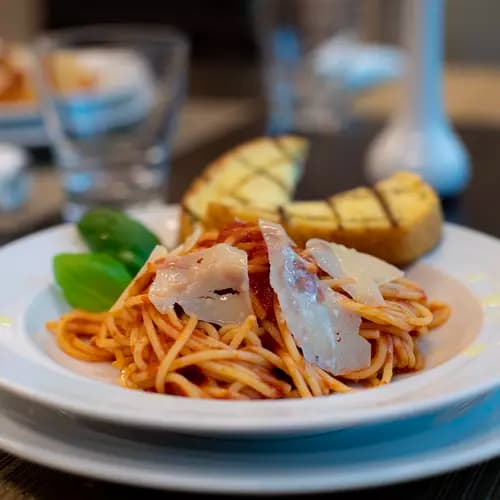 Pasta cooked with marinara sauce served with garlic bread