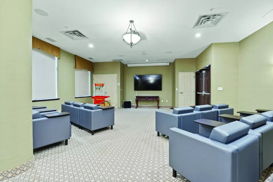 Chartwell Oakville Retirement Residence theatre with comfortable seas with side tables for snacks.