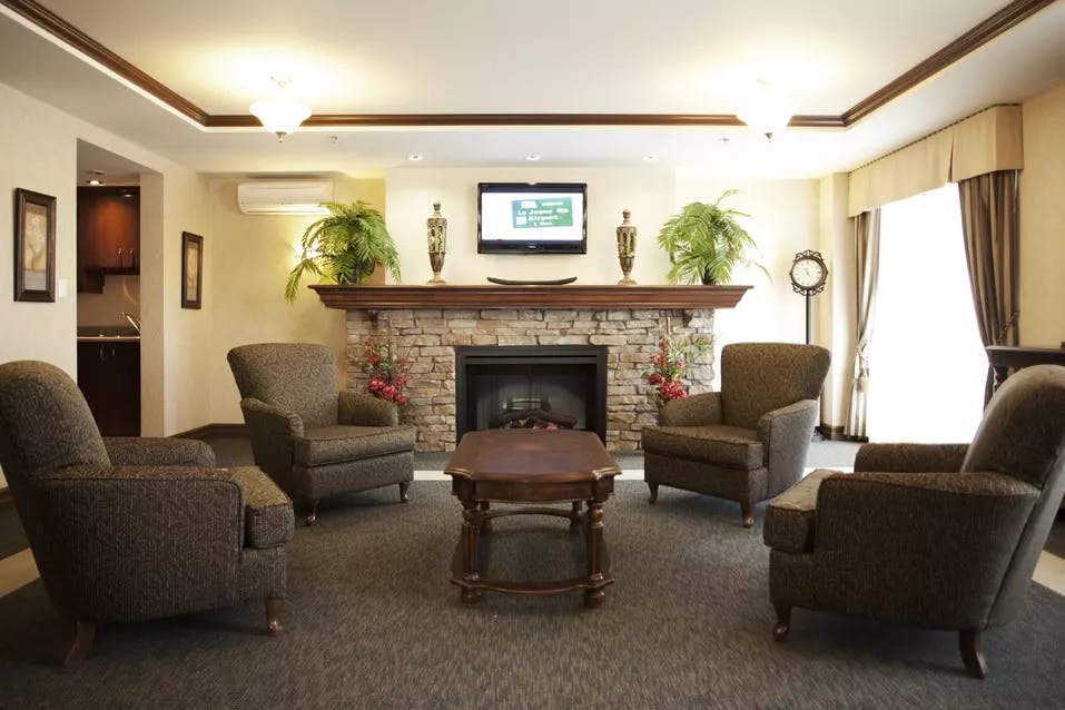 Salon commun avec fauteuils et foyer Chartwell Villa Chicoutimi résidence pour retraités