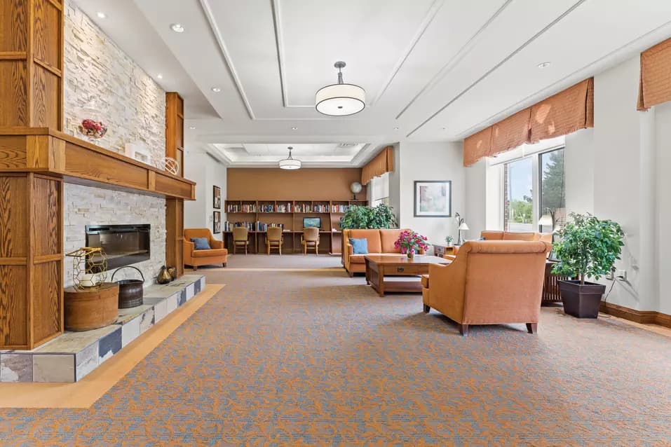 Lounge with a wide framed fireplace at Chartwell Clair Hills / Salon avec cheminée à large cadre chez Chartwell Clair Hills