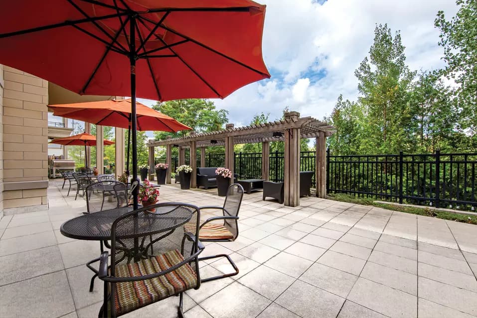 Chartwell Westmount's exterior patio with outdoor tables, chair and umbrellas