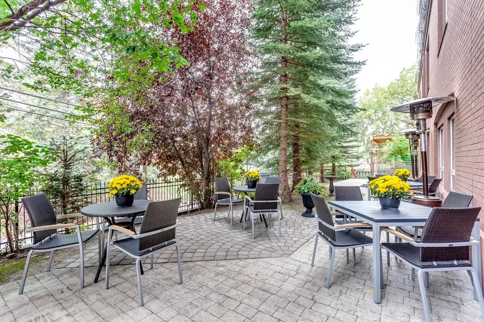 gorgeous stone patio with tables and chairs at chartwell fountains of mission retirement residence