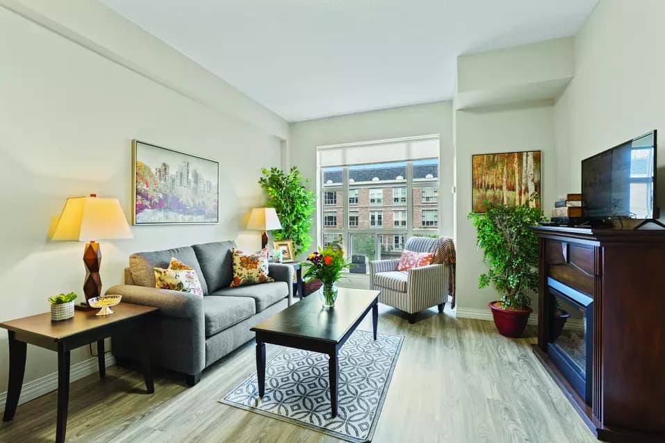 Living space in suite with furniture and TV at Chartwell Robert Speck Retirement Residence