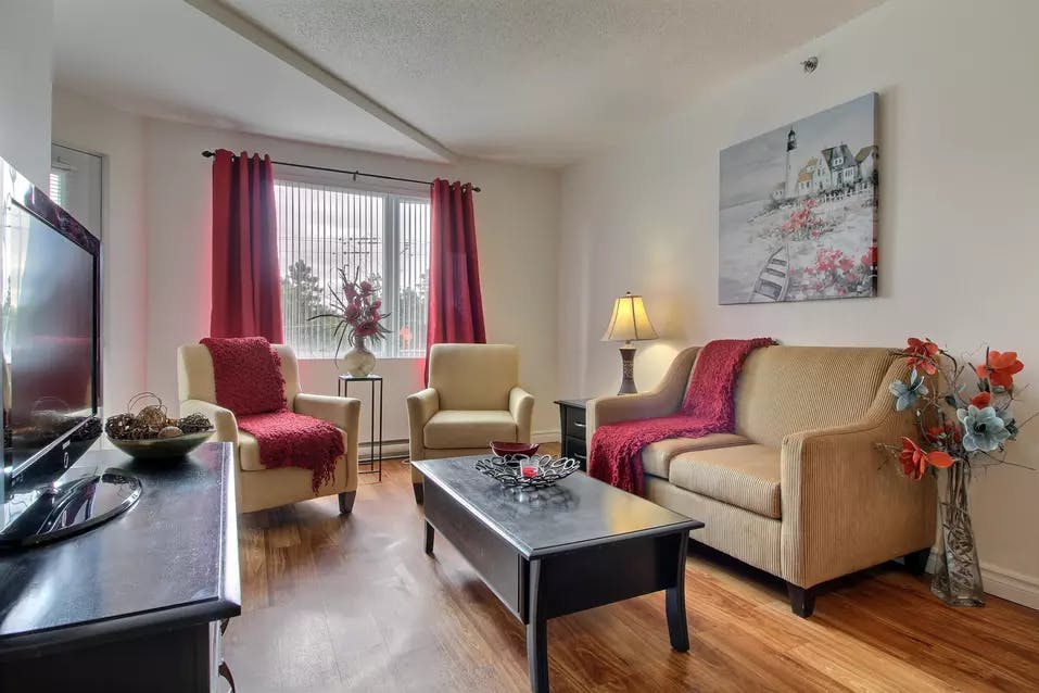 Grand salon appartement modèle avec divan et fauteuils Chartwell Villa Saguenay résidence pour retraités