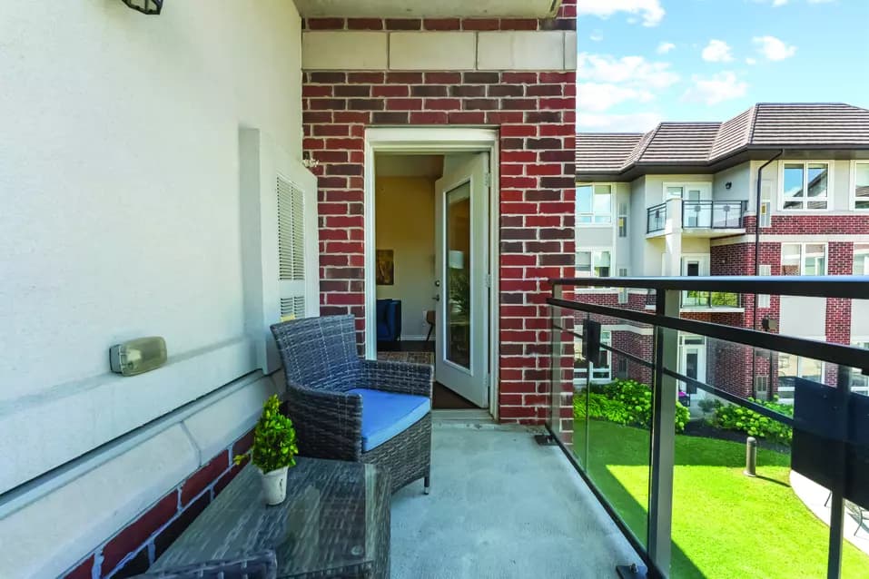 suite private patio with a patio furniture at Chartwell Deerview Crossing Retirement Residence