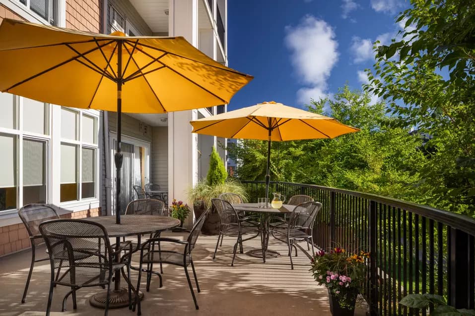 beautiful patio with furniture and umbrellas at chartwell hampton house retirement residence