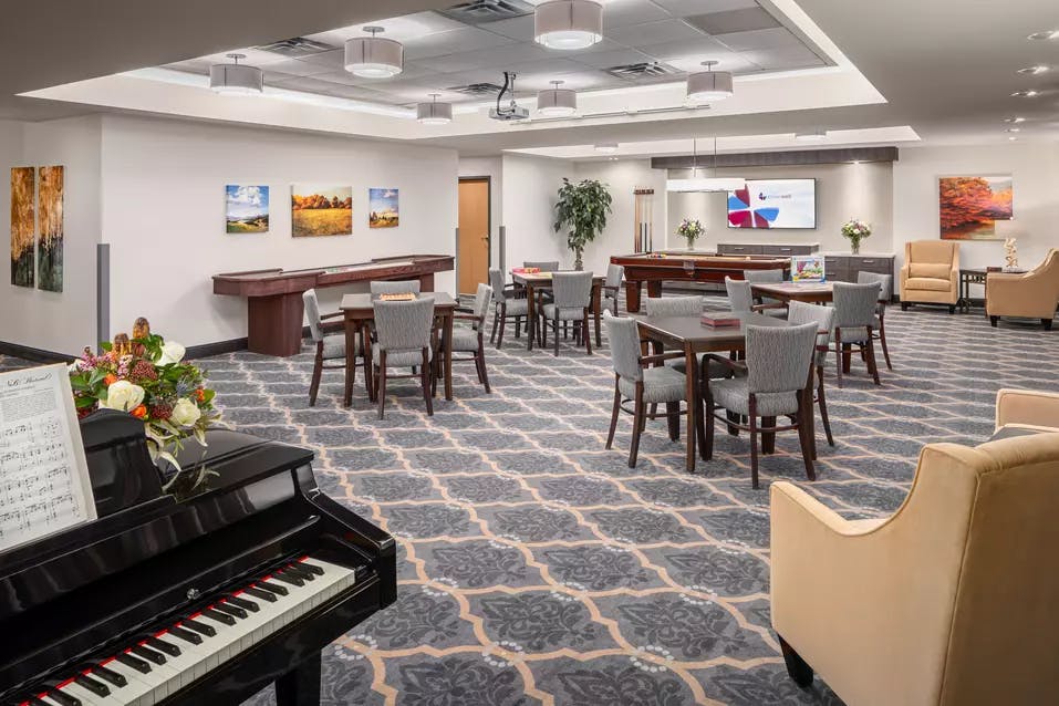 spacious bistro with a piano at chartwell fountains of mission retirement residence