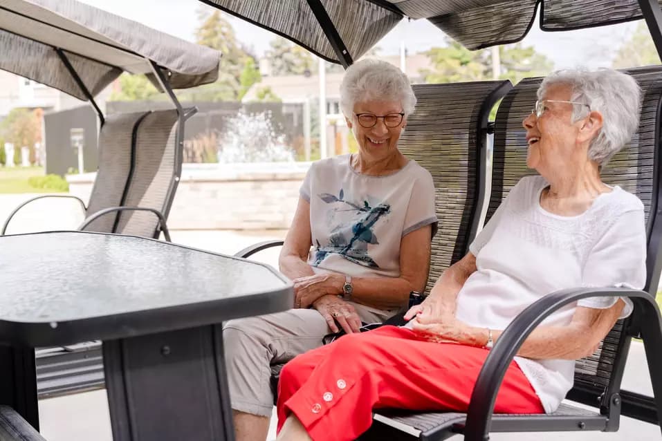 Chartwell  senior residents chatting outside in lounge chair