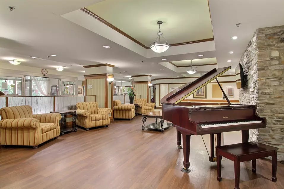 Salon commun avec piano et fauteuils Chartwell Faubourg Giffard résidence pour retraités