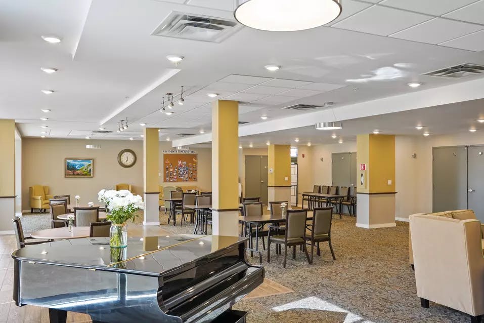 lounge with a piano at chartwell heritage valley retirement residence
