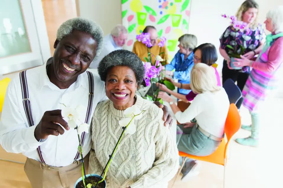 Diverseseniorcoupletakinganorchidpottingclasswithfriends.