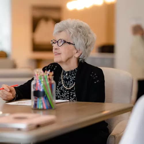 Chartwell Senior resident enjoying art session by colouring a picture