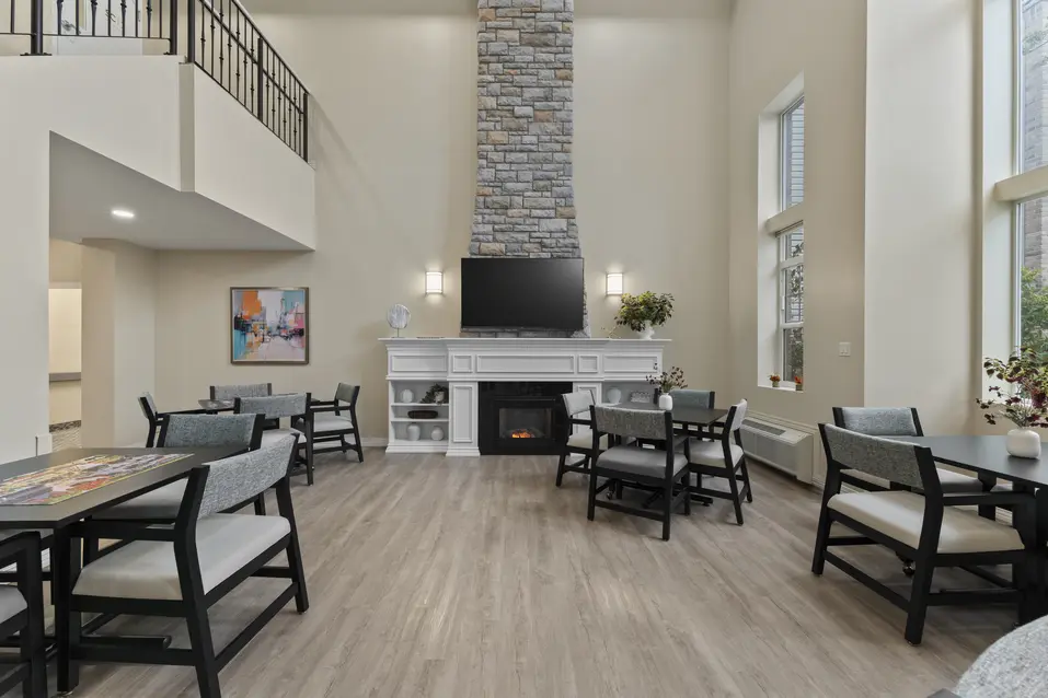 Resident lounge area with fireplace and comfortable seating in the main lobby at Chartwell Royal Oak Village. / Espace de détente avec foyer et sièges confortables dans le hall principal au Chartwell Royal Oak Village.