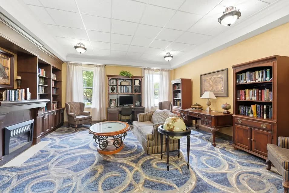 Library with fireplace, armchairs and bookshelves at Chartwell Riverside