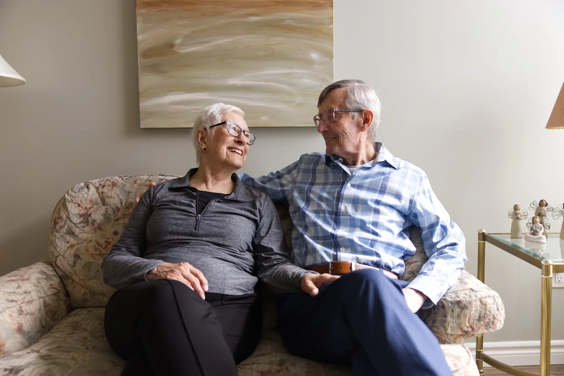 Senior couple is sitting on a cozy sofa in their living room / Un couple âgé est assis sur un canapé confortable dans leur salon