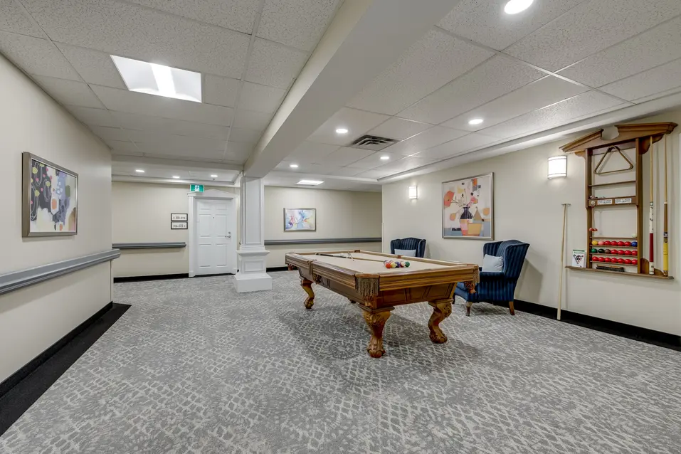 Games lounge with billiards table and social seating area at Chartwell Welland / Salon de jeux avec table de billard et espace de rencontre à Chartwell Welland