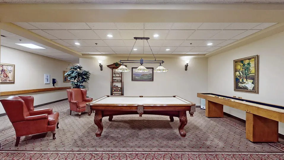 Billiards/ games room with wing back chairs at Chartwell Amherstburg