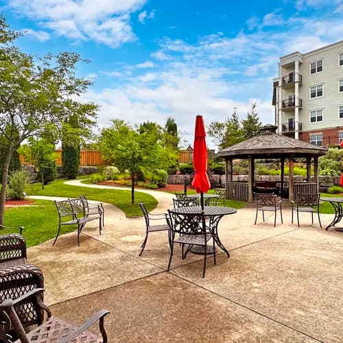 View of patio with chairs and red umbrellas at Chartwell Owen Sound