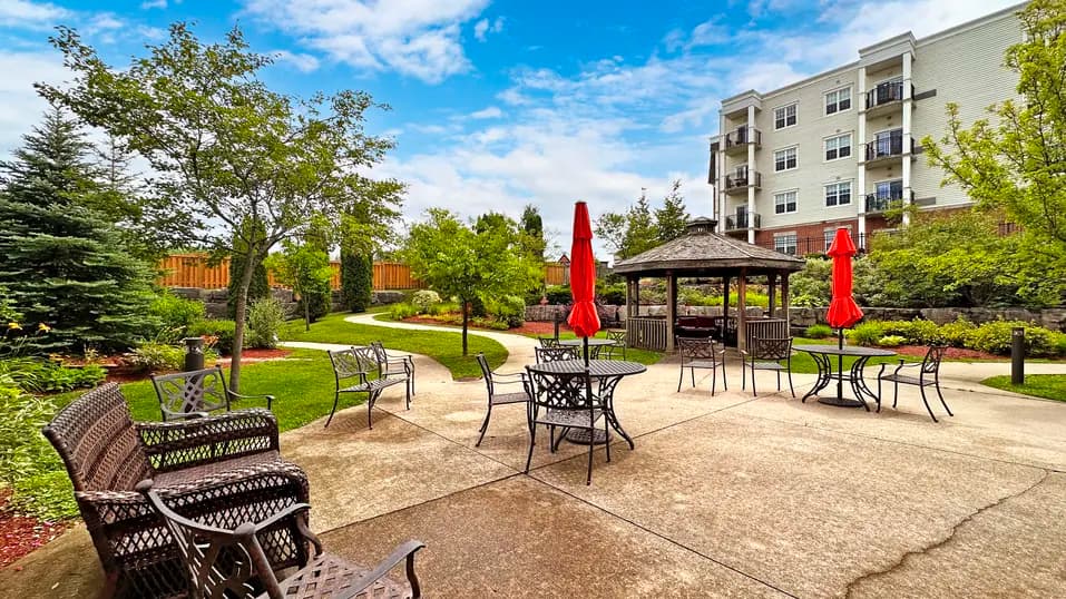 View of patio with chairs and red umbrellas at Chartwell Owen Sound