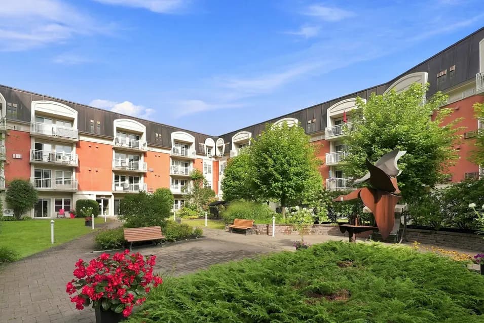 Jardin central avec aménagement paysager et aire de repos au Chartwell Seigneuries du Carrefour. / Central garden with landscaped grounds and seating area at Chartwell Seigneuries du Carrefour.