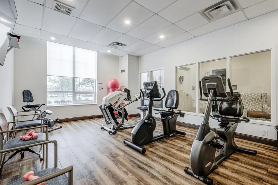 Fitness centre with cardio equipment and strength training area at Chartwell ValleyVista / Centre de conditionnement physique avec appareils cardiovasculaires et espace d’entraînement à Chartwell ValleyVista